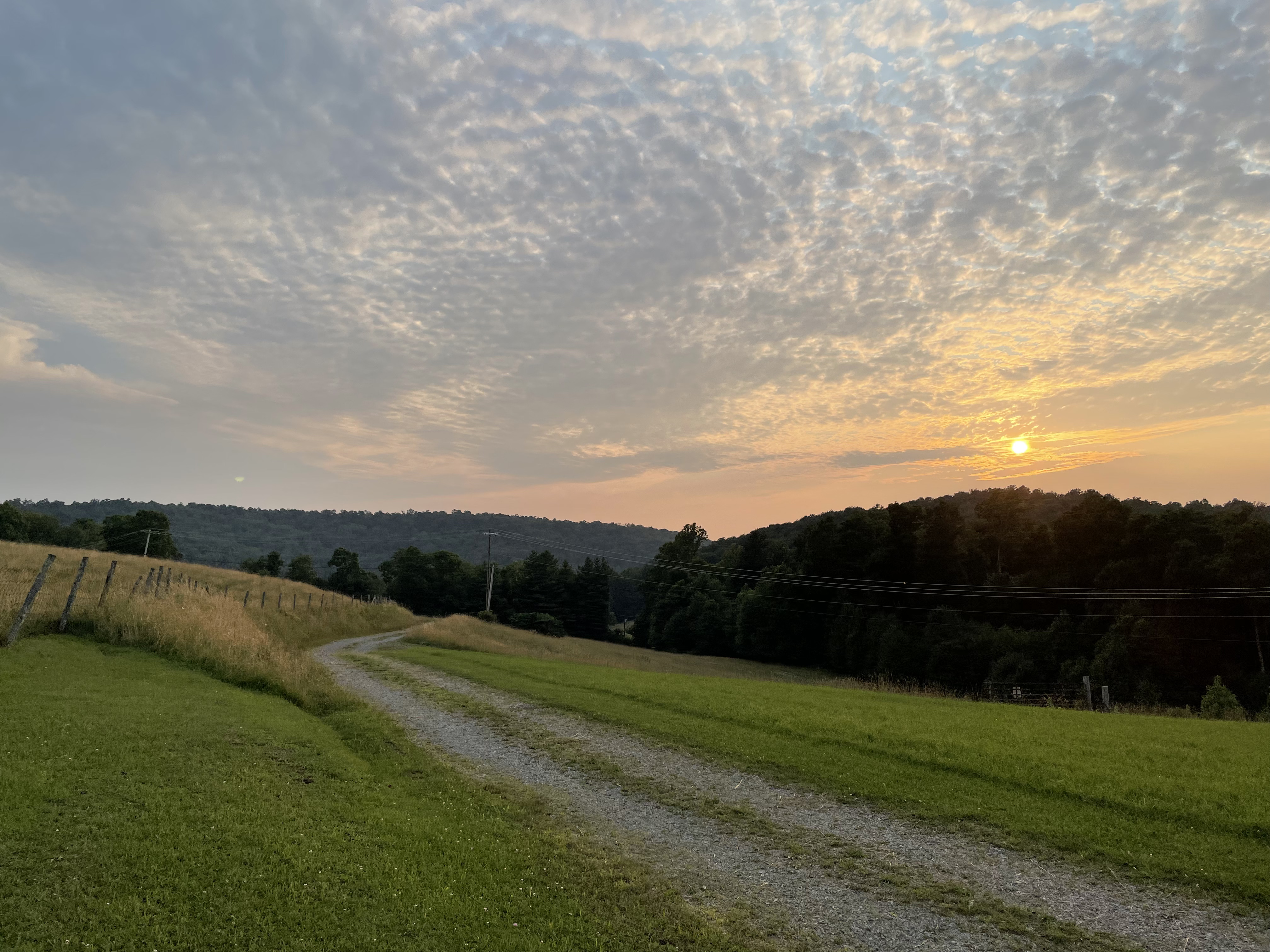image of a beautiful West Virginia sunset overlooking a dirt road.